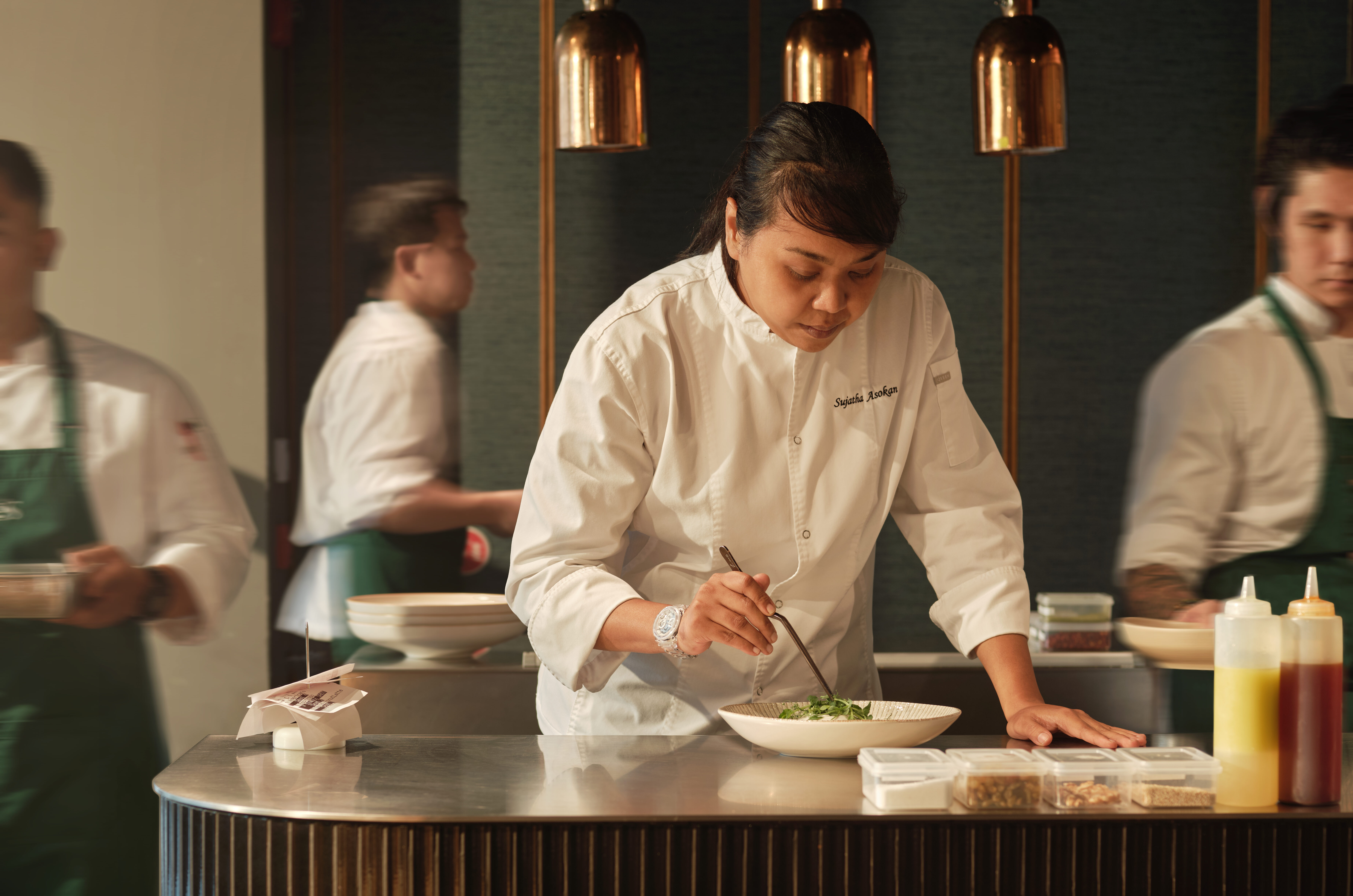 Executive Chef Sujatha Asokan carefully plates a modern Asian dish at the open kitchen of Kee’s Restaurant & Bar, located within 21 Carpenter, Singapore.