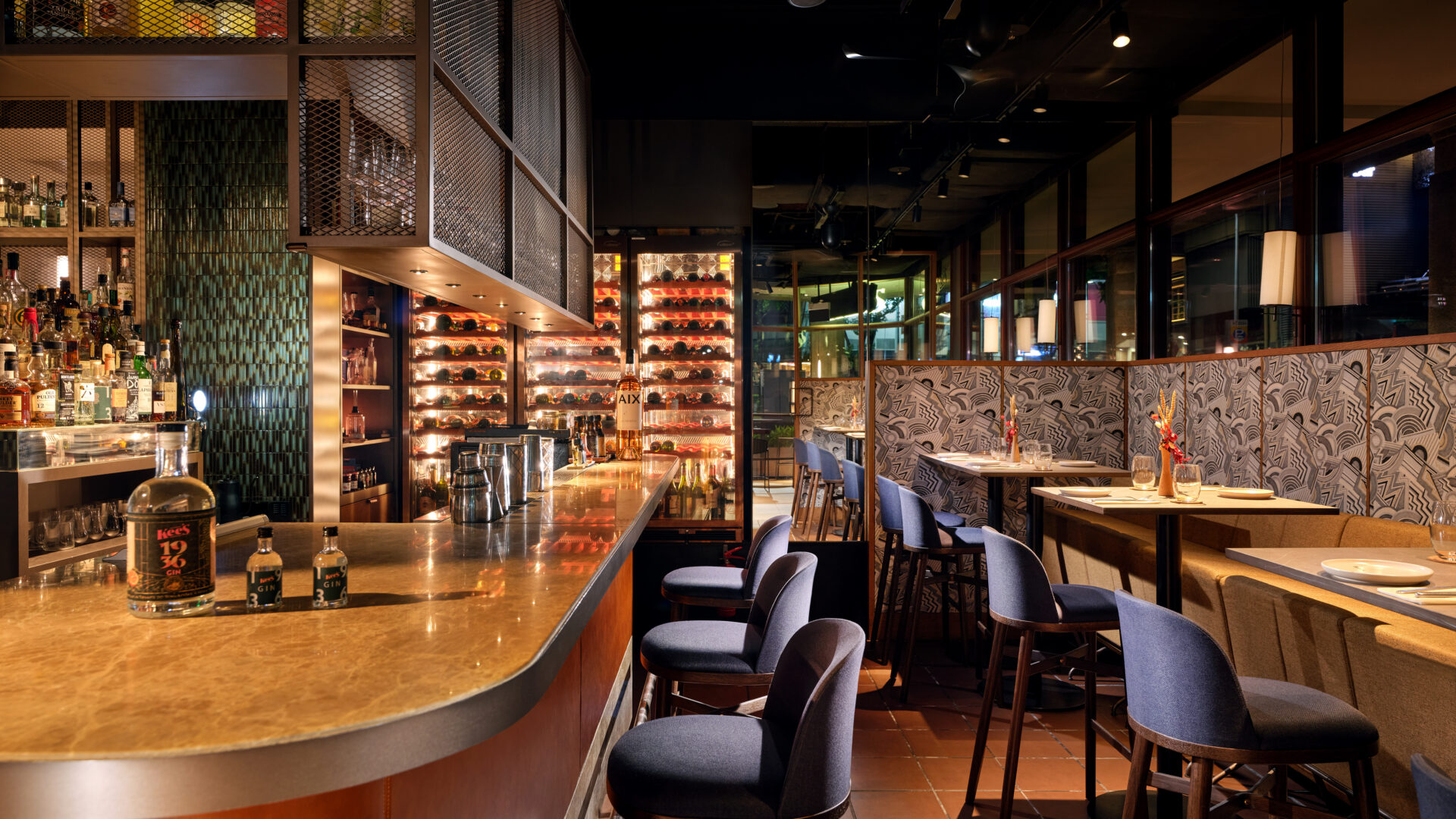 The Parlour at Kee’s | Modern Asian Bar & Lounge at 21 Carpenter Singapore Interior of The Parlour at Kee’s, 21 Carpenter Singapore, featuring a marble bar counter, blue upholstered stools, illuminated wine displays and cosy dining booths.